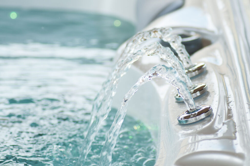 Crystal-clear water flowing from hot tub jets during a water-care visit